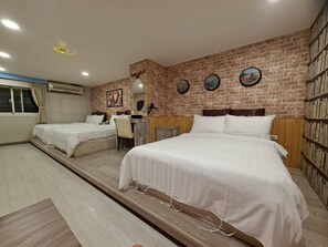 Une chambre d’hôtel avec deux lits, un bureau et un mur en briques.