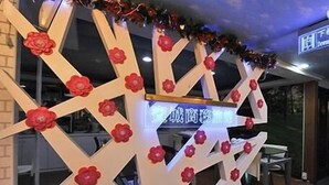 Un mur décoratif orné de motifs géométriques et de fleurs rouges.