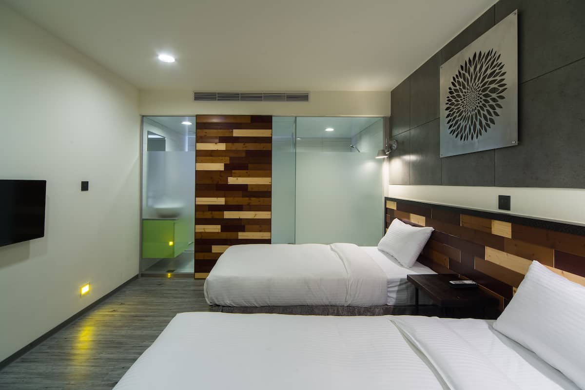 Une chambre d’hôtel moderne avec deux lits, un téléviseur à écran plat, un mur décoratif en bois et un grand élément décoratif mural.