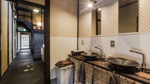 A modern bathroom with a large mirror, two sinks, and a towel rack. - Traditional Kyoto Home Bifuku Roujiya (Kyoto)