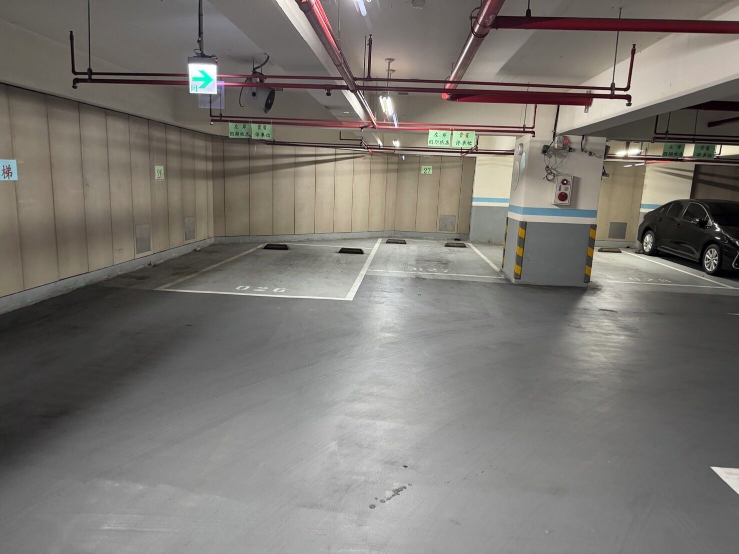 An underground parking garage with clear directional signage, including an exit arrow.