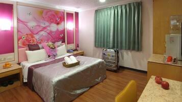 A hotel room with a bed, a desk, a chair, a water dispenser, and a wall with floral wallpaper.