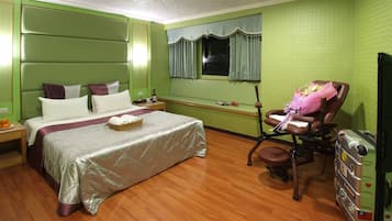A room with a bed, a chair, a desk, and a suitcase.