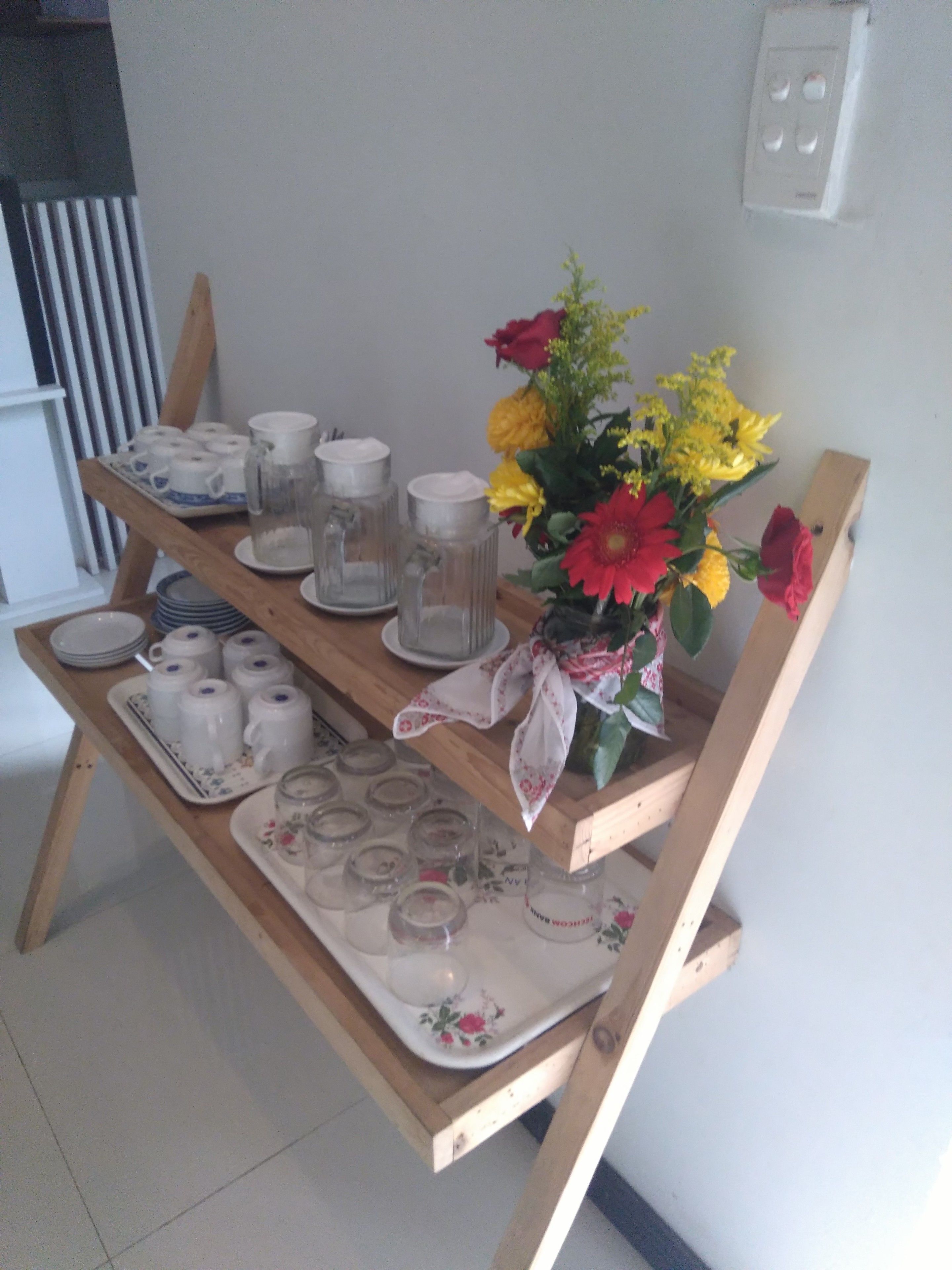 A wooden table with various glassware and a floral arrangement.