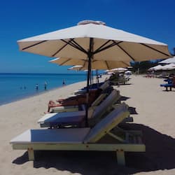 Praia particular, areia branca, espreguiçadeiras, guarda-sóis