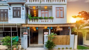 A two-story building with a balcony, a signboard, and a wooden fence. - Lang Dong An Bang (Da Nang)