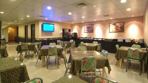 A restaurant with tables and chairs, a television, and a counter with food items. - Tong Bing Express (Hsinchu)