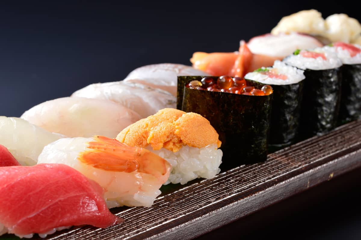 Une variété de sushis présentés sur un plateau en bois.