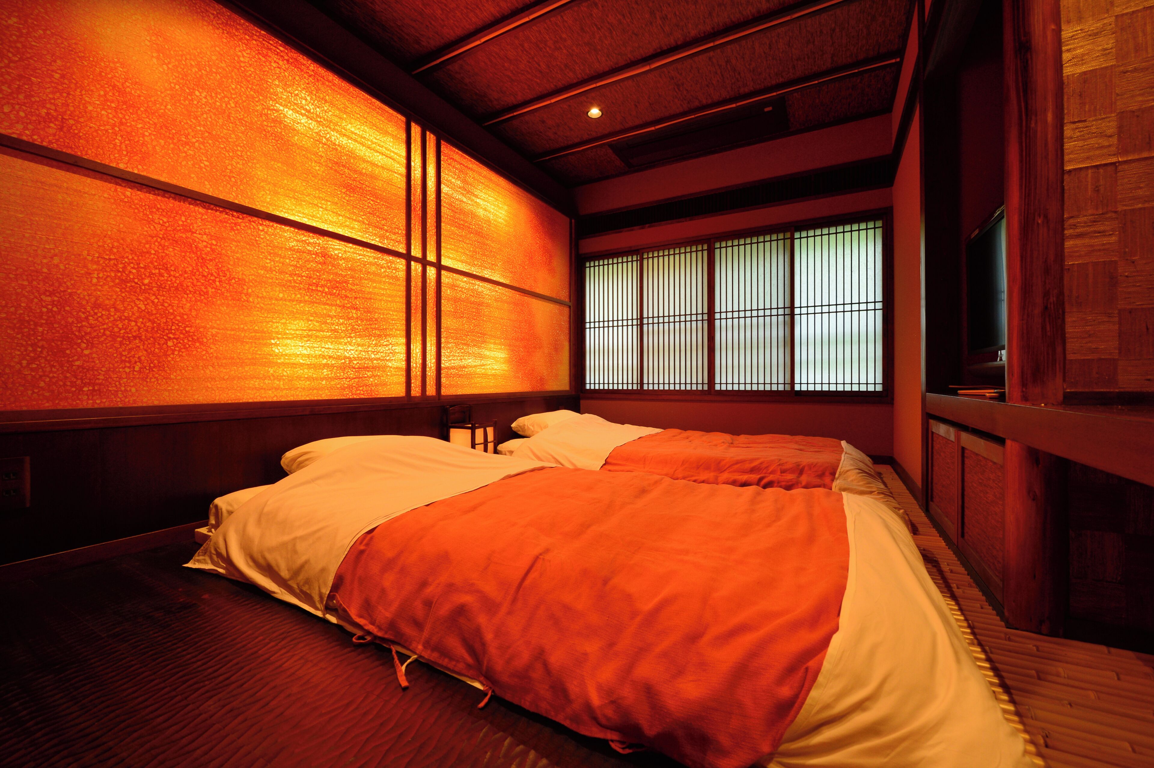 A traditional Japanese-style room with tatami flooring, a low wooden ceiling, and sliding shoji doors.