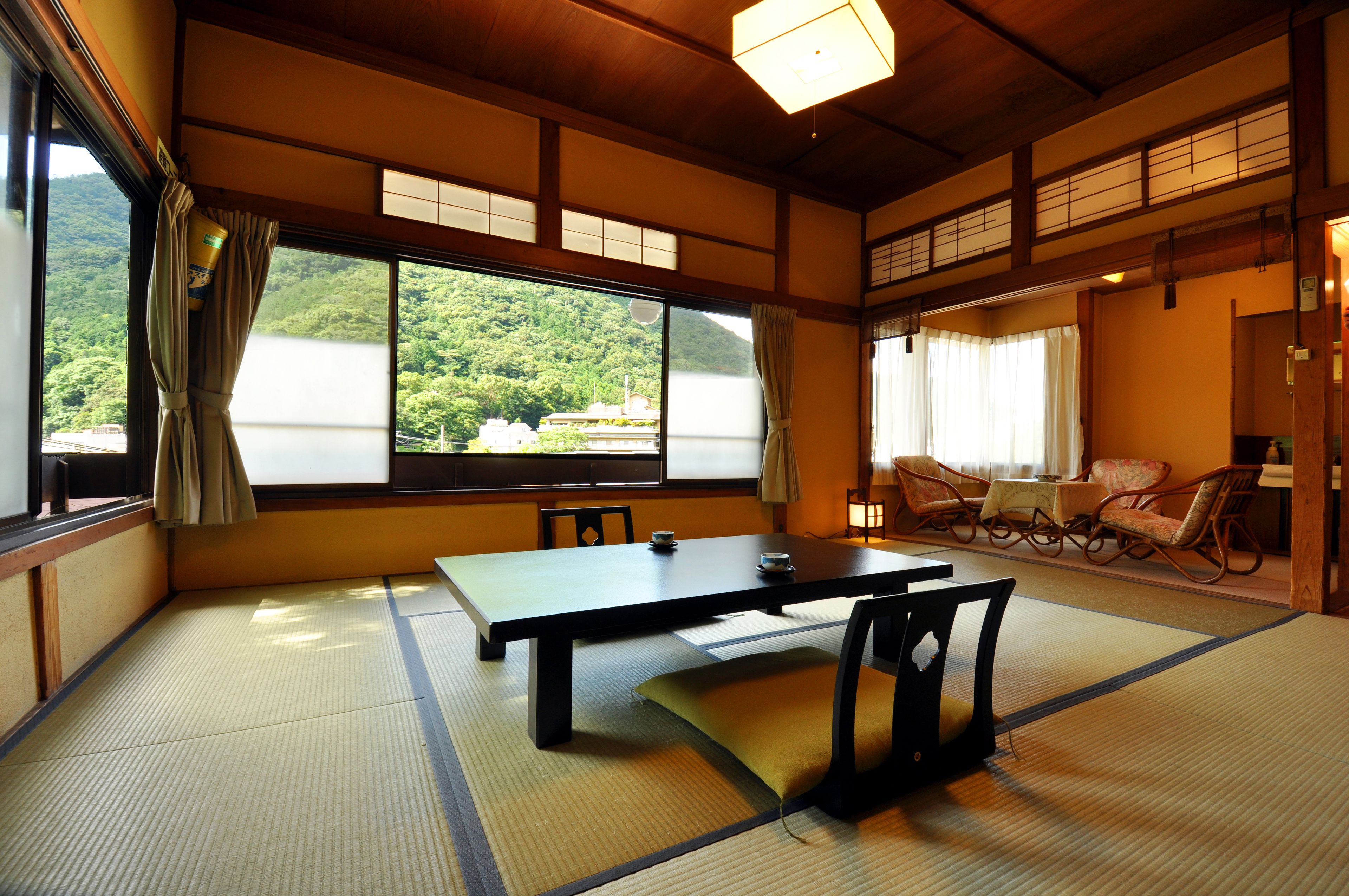 Una tradizionale stanza giapponese con pavimento in tatami, un tavolino e sedie.