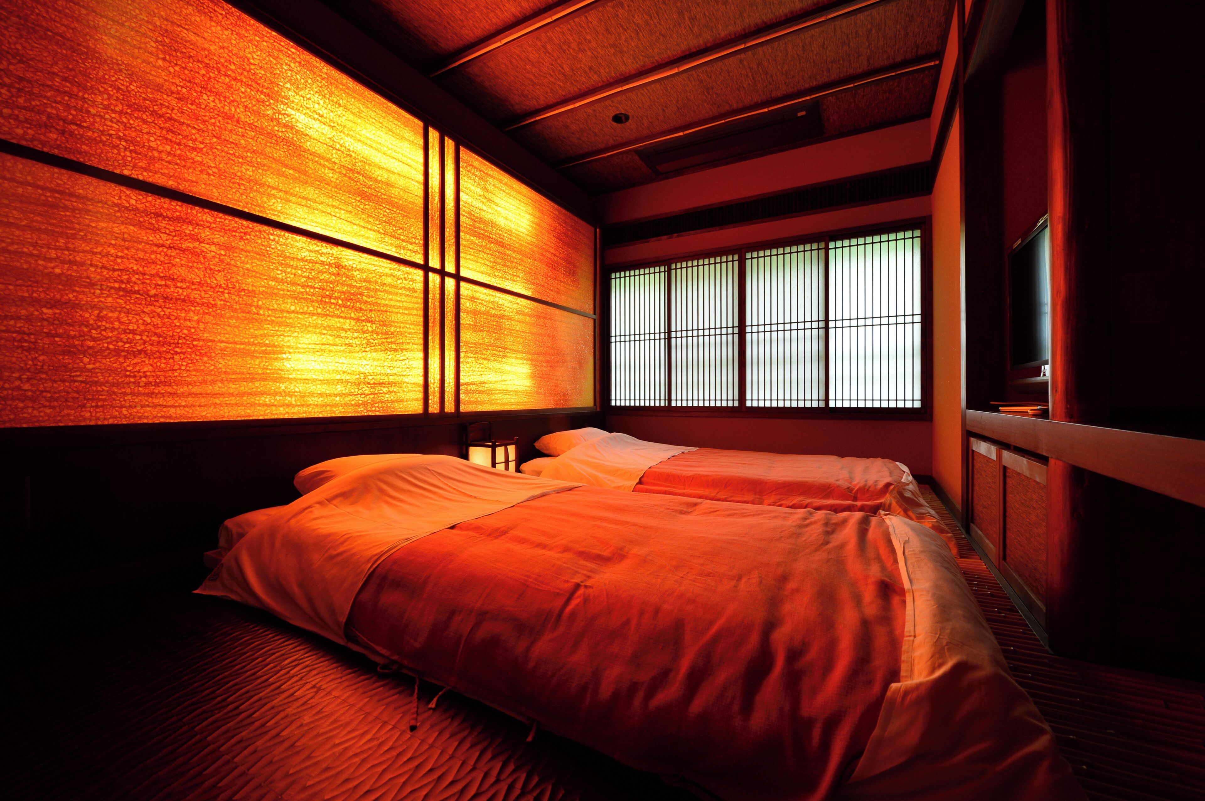 A traditional Japanese room with tatami flooring, sliding shoji doors, and a low ceiling.