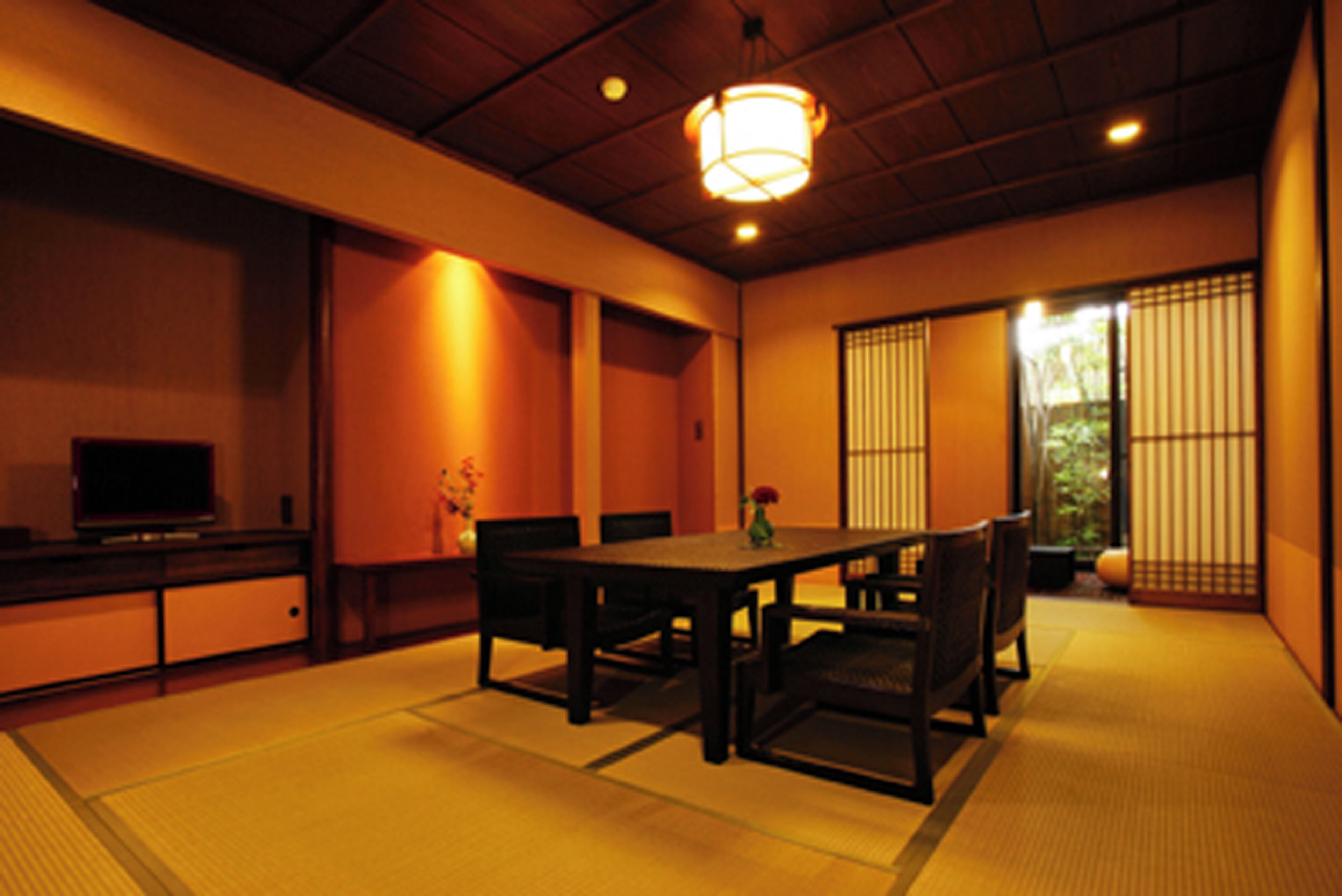 A traditional Japanese room with tatami flooring, a low table, and sliding doors.