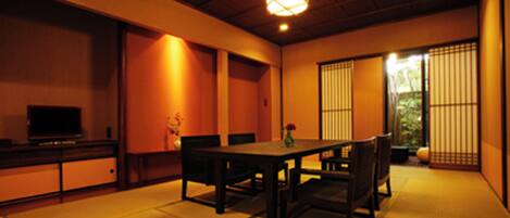A traditional Japanese room with tatami flooring, a low table, and sliding doors.
