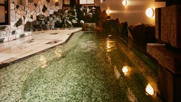 A pool with a stone wall and a stone ledge.