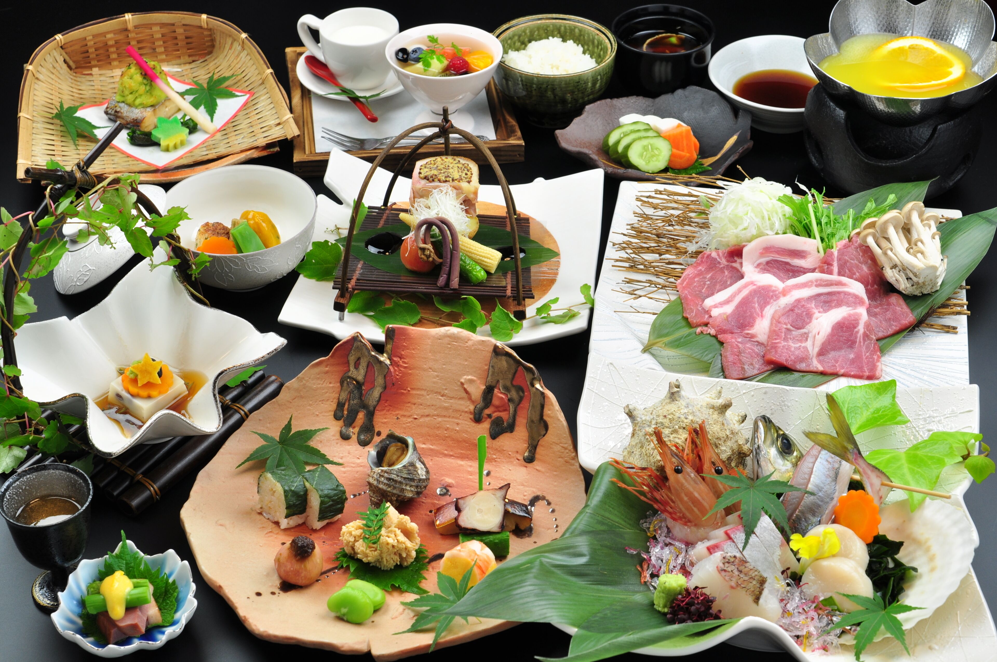 A variety of Japanese dishes including sushi, sashimi, and a hot pot setup.