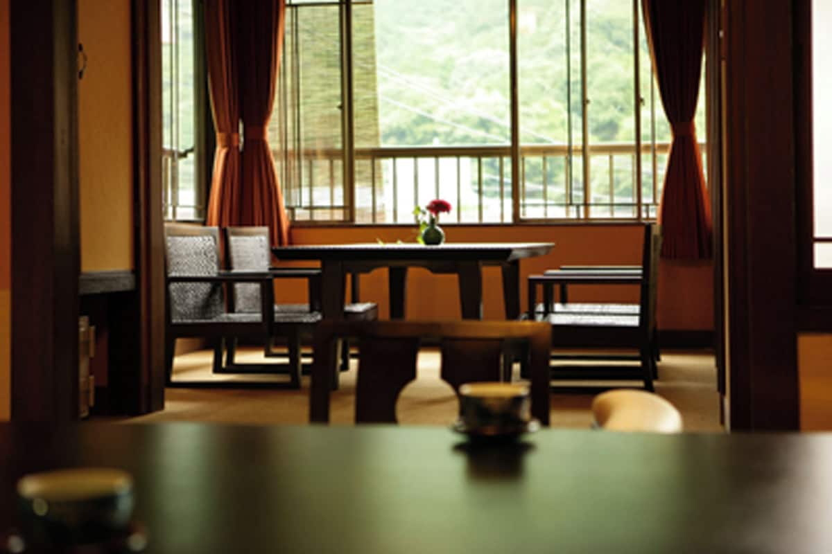 Un coin repas avec une table, des chaises et un vase de fleurs.