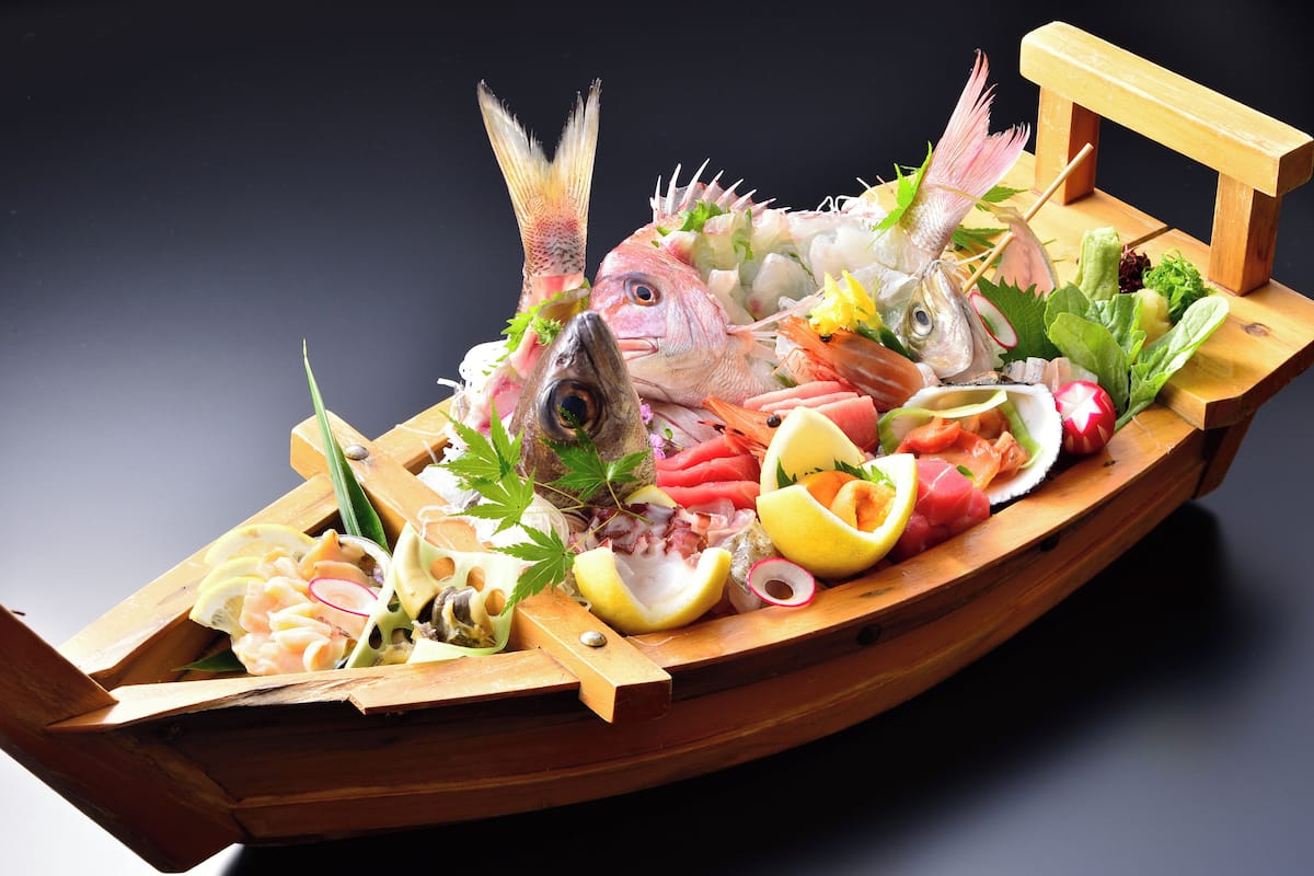 Un bateau en bois rempli de divers fruits de mer et légumes.