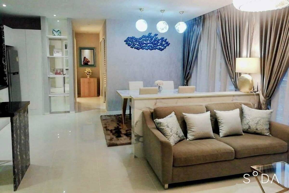 A modern living room with a sofa, a dining area, and a TV.