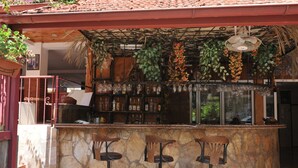 A bar area with stone walls, three stools, and a variety of bottles and glasses. - Best House Hotel (Alanya)