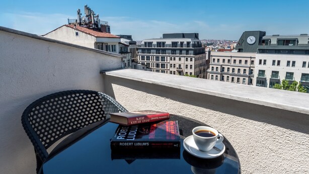 A balcony with a table, a chair, a book, and a cup of coffee. - Taksim Trust Hotel (Istanbul)