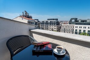 A balcony with a table, a chair, a book, and a cup of coffee. - Taksim Trust Hotel (Istanbul)