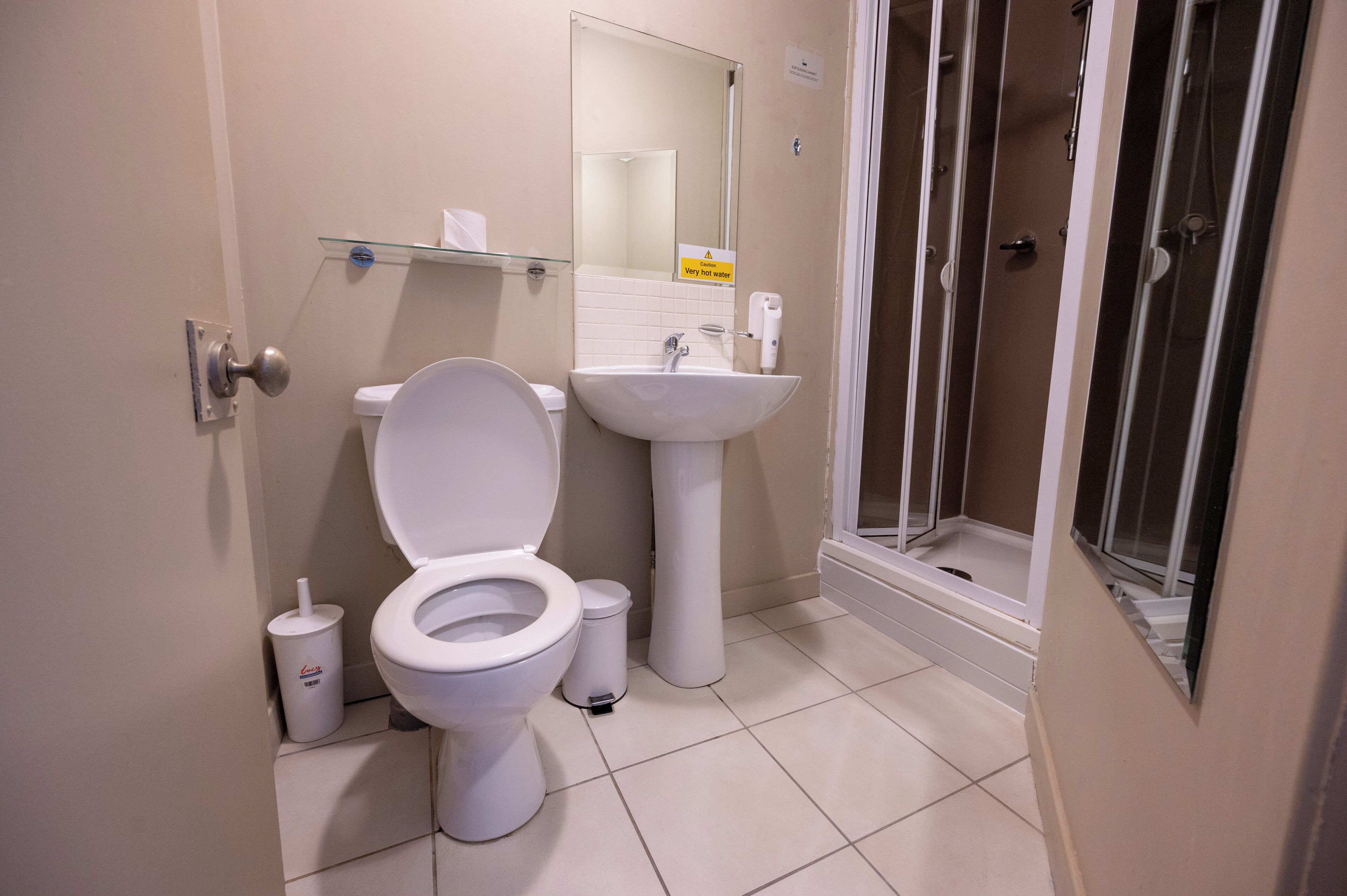 A bathroom with a toilet, sink, and shower.