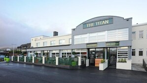 Un hotel llamado 'The Titan', con entrada a un bar y recepción de hotel.
