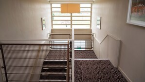 Una escalera con barandillas metálicas y un suelo con estampado.