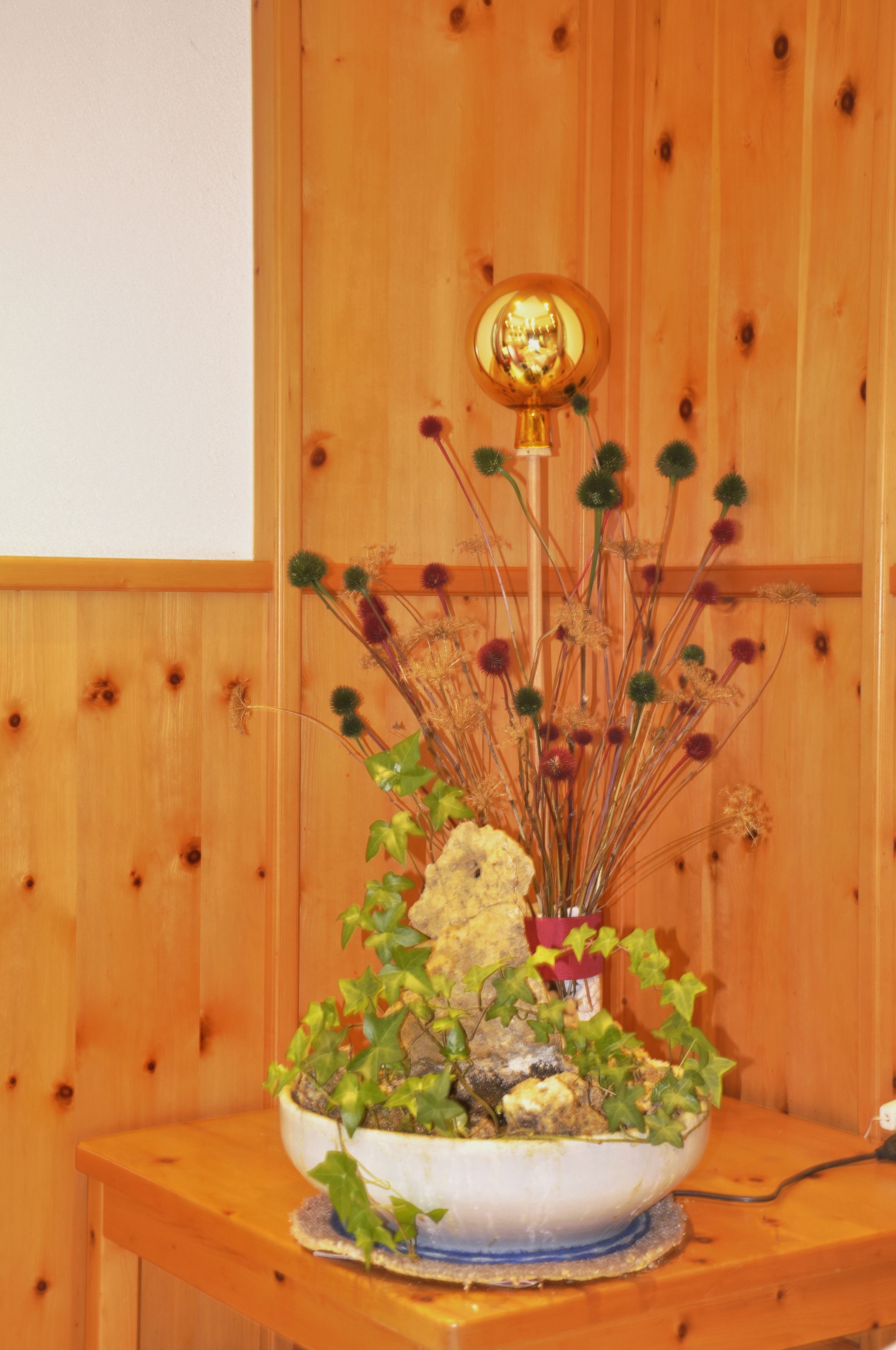 Una mesa de madera con un arreglo decorativo de plantas.
