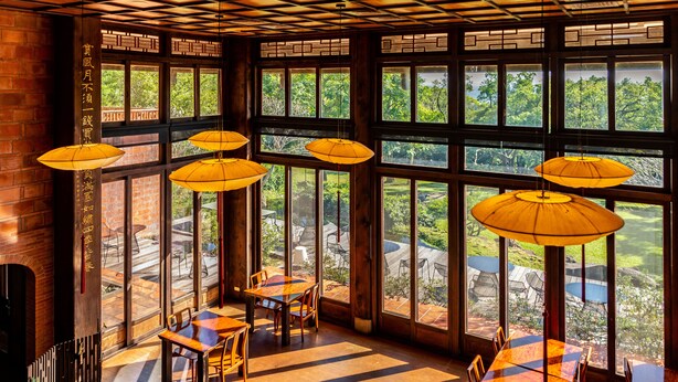 A restaurant with large windows, wooden tables, and hanging yellow umbrellas. - The One Nanyuan (Xinpu)
