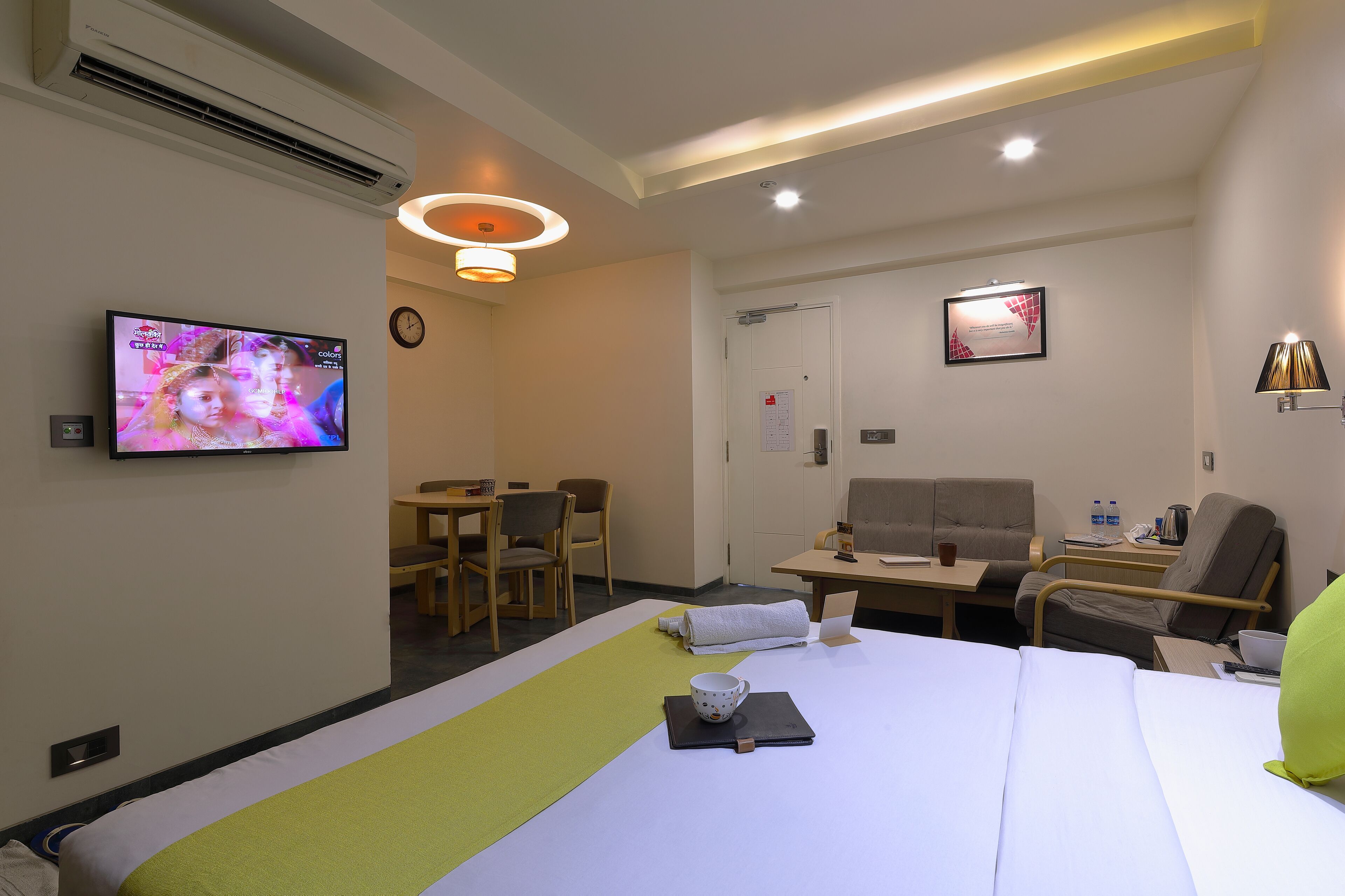 A hotel room with a bed, a television, a desk, and a chair.