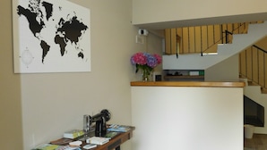 Une cuisine moderne dotée d’un îlot central, d’une carte du monde accrochée au mur et d’un escalier menant à un niveau supérieur.
