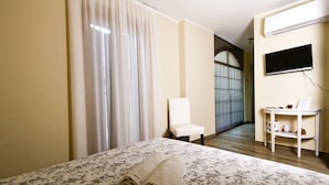 Une chambre d’hôtel avec un lit, une chaise, une petite table avec une tasse et une fenêtre.