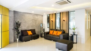 A modern living room with a sofa set, a coffee table, and a potted plant. - The Circle Hotel (Buriram)