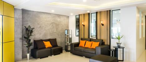 A modern living room with a sofa set, a coffee table, and a potted plant.