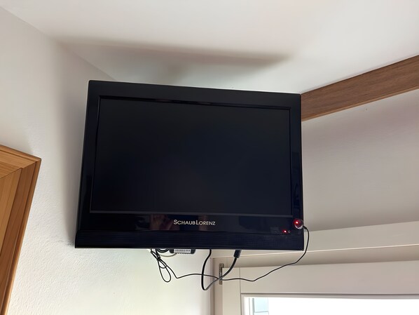 Un televisor de pantalla plana montado en la pared, con el nombre de marca 'Schaub Lorenz' visible.