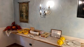 A buffet setup with various food items, yellow baskets, and a wall-mounted light fixture. - Meublè Bar Giustina (Auronzo di Cadore)