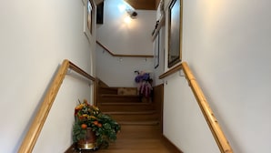A wooden staircase with a potted plant at the bottom. - Meublè Bar Giustina (Auronzo di Cadore)
