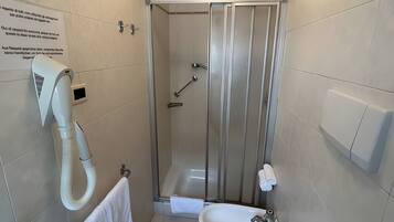 Un bagno con doccia, WC e lavandino.