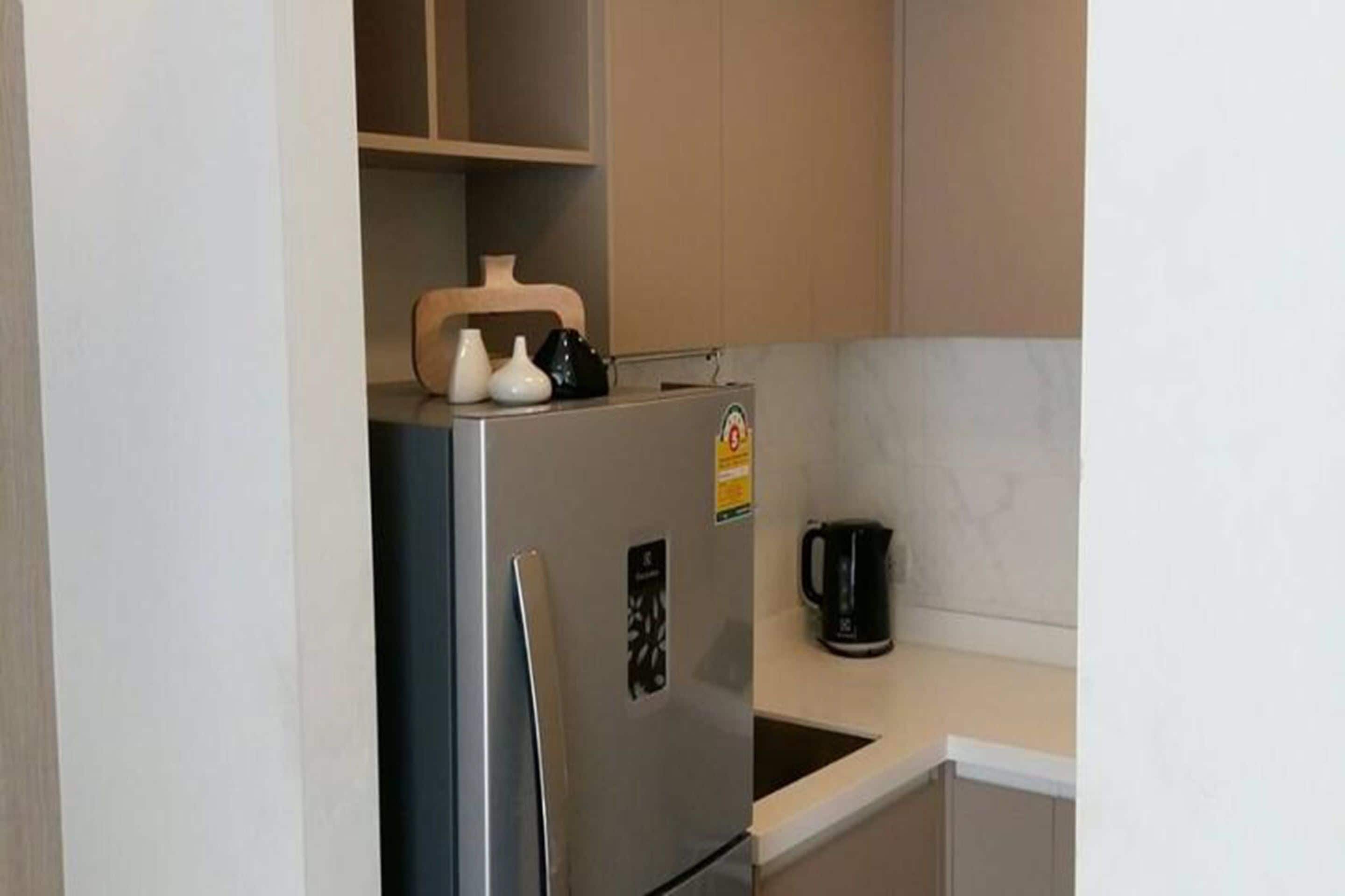 A compact kitchen with a refrigerator, a coffee maker, and a microwave.