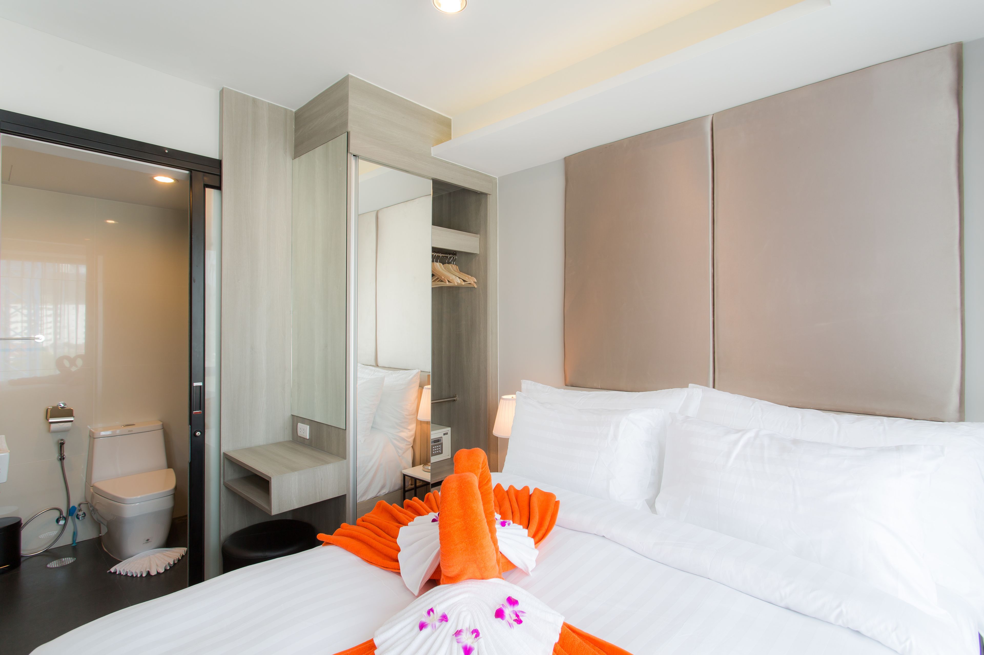 Una habitación de hotel con cama, baño y armario.