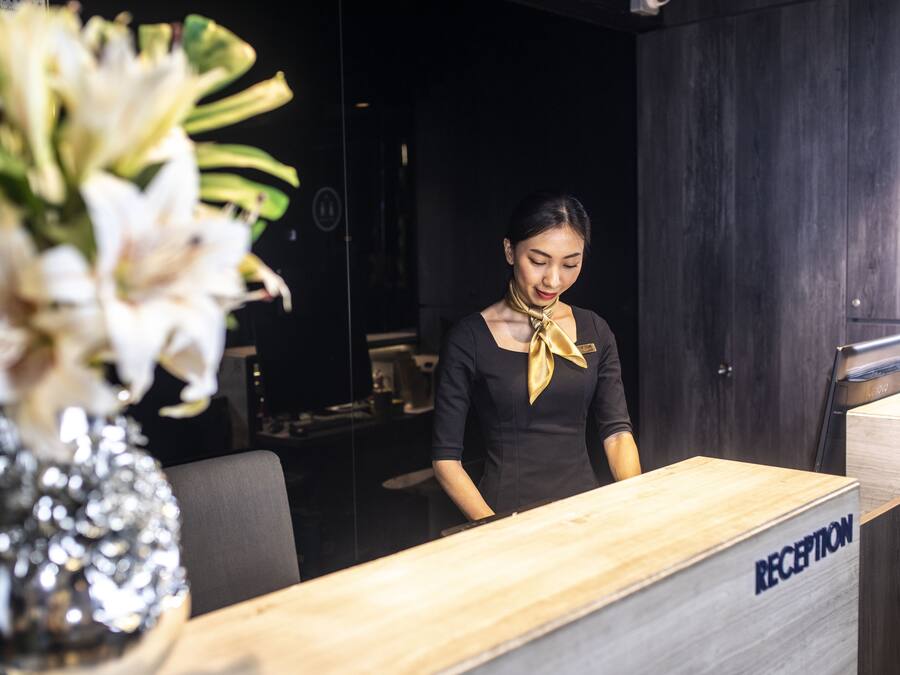 Un mostrador de recepción con cubierta de madera y un cartel que dice "RECEPTION".