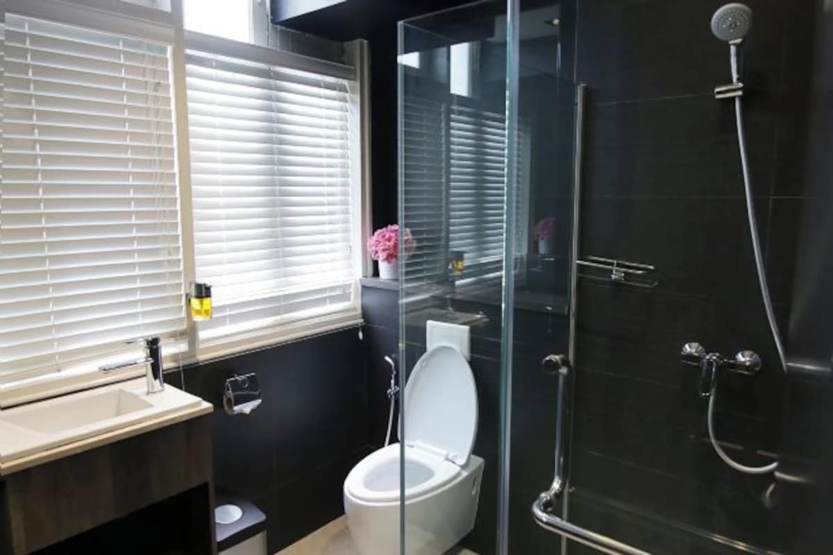 Un baño moderno con ducha de vidrio, inodoro y lavabo.
