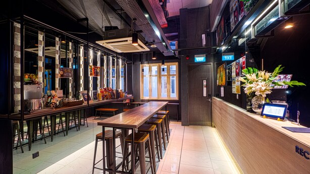 Een moderne bar met hoge krukken, een houten toonbank en een groot raam.