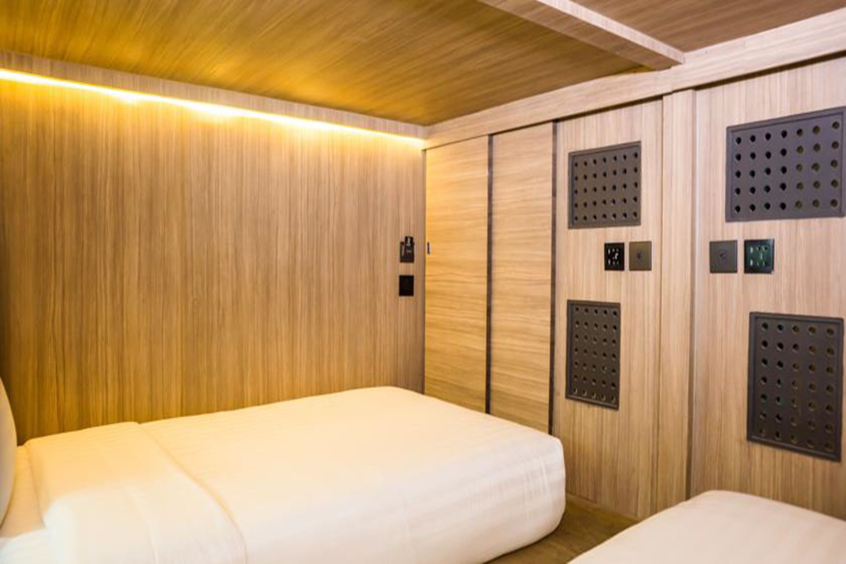 A hotel room with a wooden panel wall, a bed, and a small seating area.