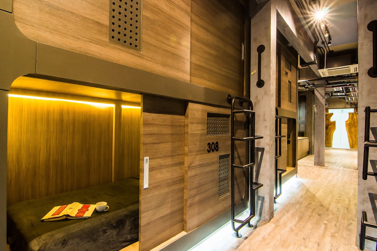 A modern elevator with a wooden finish, a visible number "308", and a small seating area with a magazine and a cup.