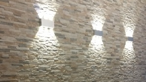 A textured stone wall with a patterned rug at the bottom. - La Maison des Rêves (Syracuse)