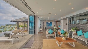 A modern interior with a pool, lounge chairs, and a dining area. - Bluesiam Villa (Choeng Thale)