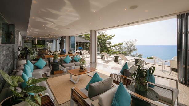 A modern interior with a seating area, large windows, and a view of the sea. - Bluesiam Villa (Choeng Thale)