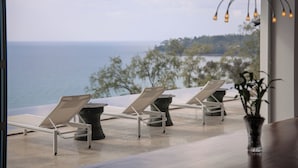 A view of a seaside lounge area with lounge chairs and a potted plant. - Bluesiam Villa (Choeng Thale)
